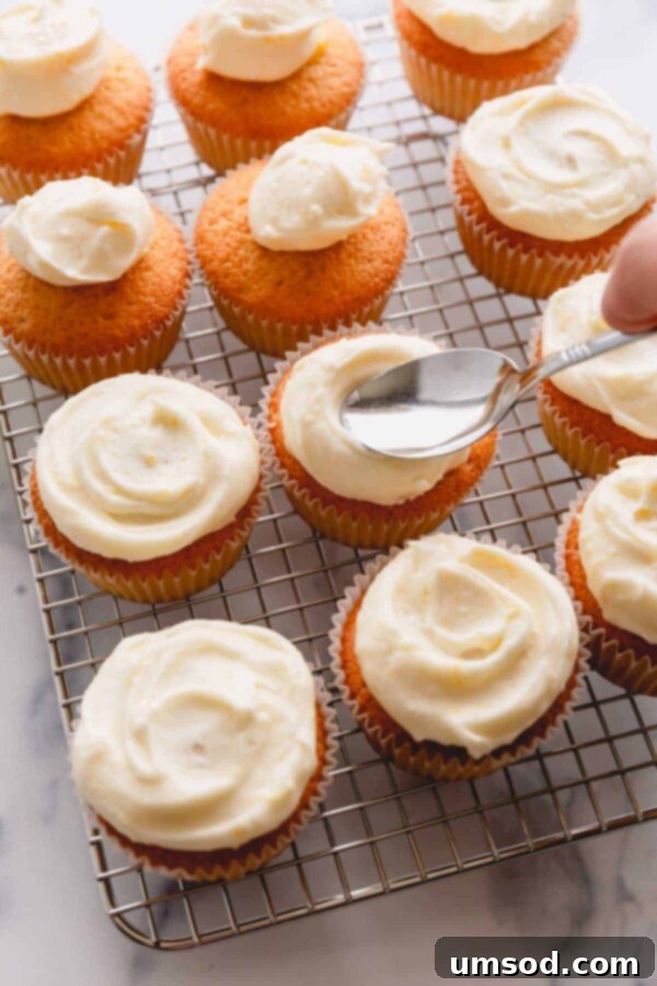 frosting cupcakes with a spoon.