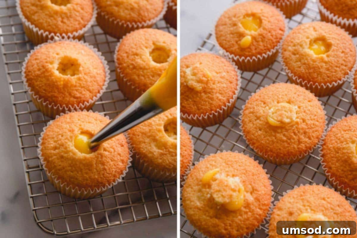 piping lemon curd into lemon cupcakes.