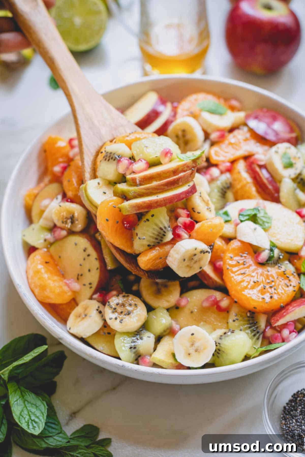 Fresh Fruit Medley 6 A large spoonful of vibrant fruit salad being lifted from a bowl, showcasing its freshness.