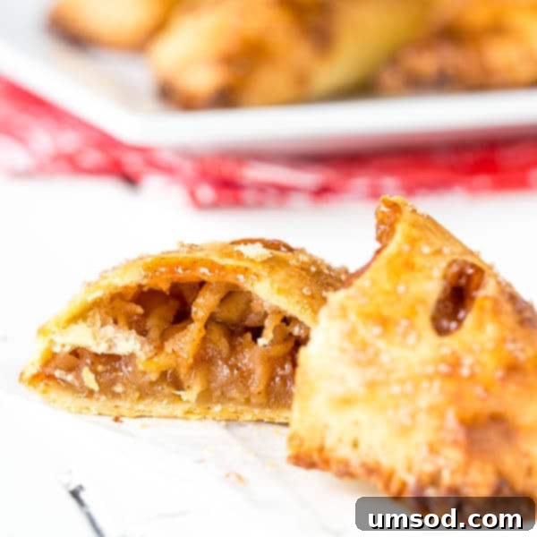 Flaky Apple Hand Pies 5 A baked apple pie turnover, split in half to reveal the rich apple filling and flaky crust.
