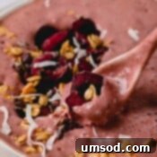 A spoonful of chocolate cherry smoothie with fresh cherries, a final shot of the black forest smoothie bowl.