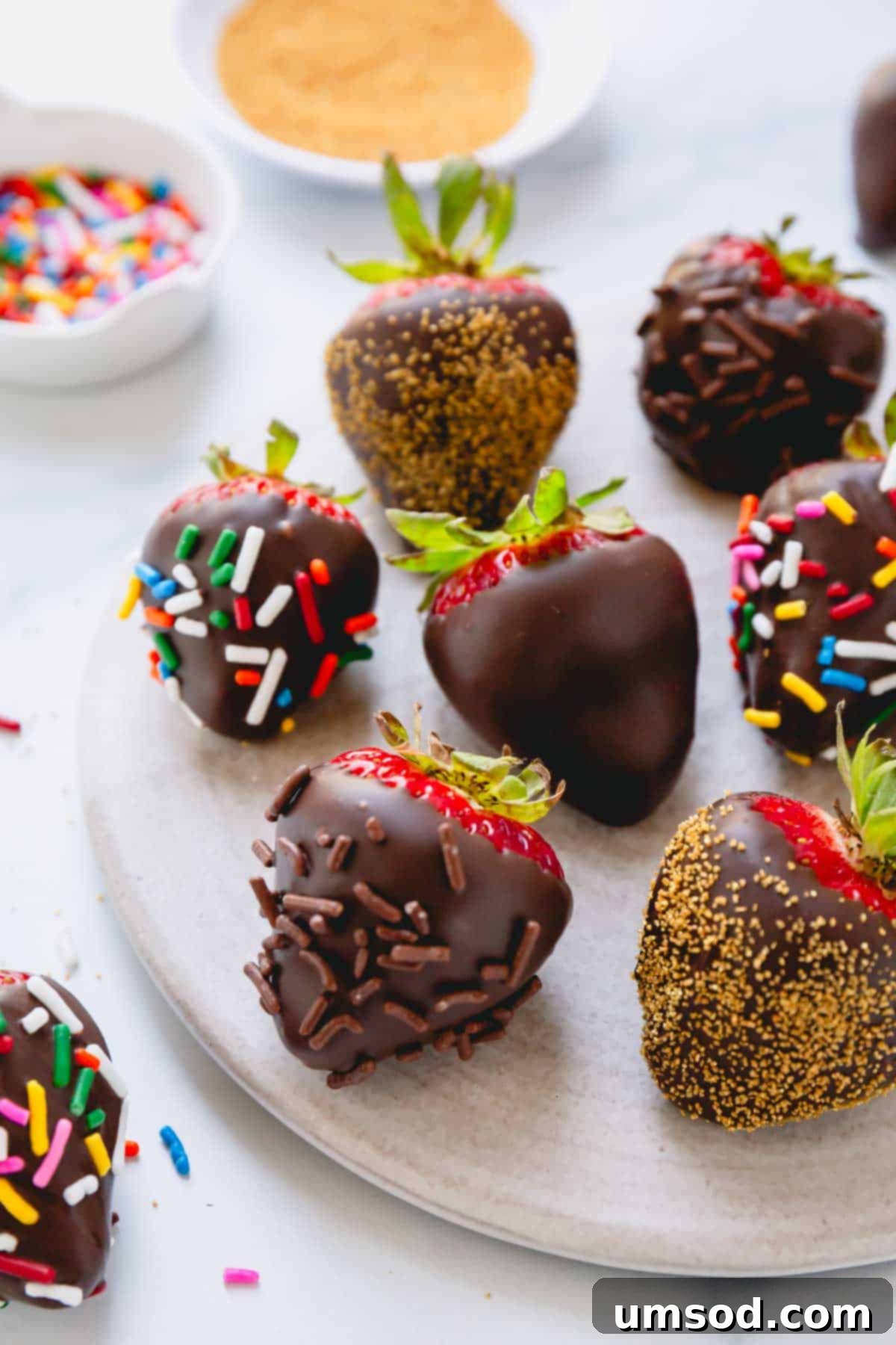 Chocolate covered strawberries coated with multi-color, chocolate, and gold sprinkles.