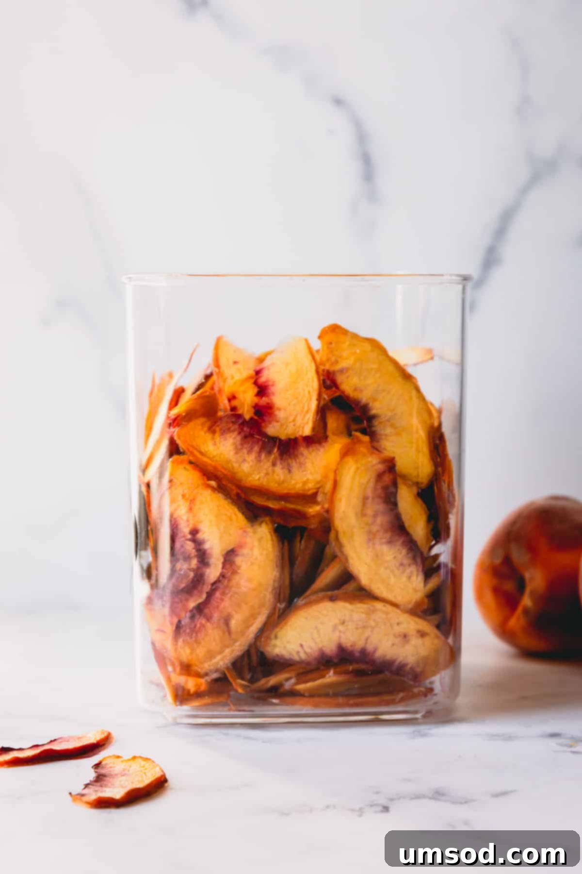 A beautiful glass jar filled with perfectly dehydrated peach pieces, ready for the pantry.