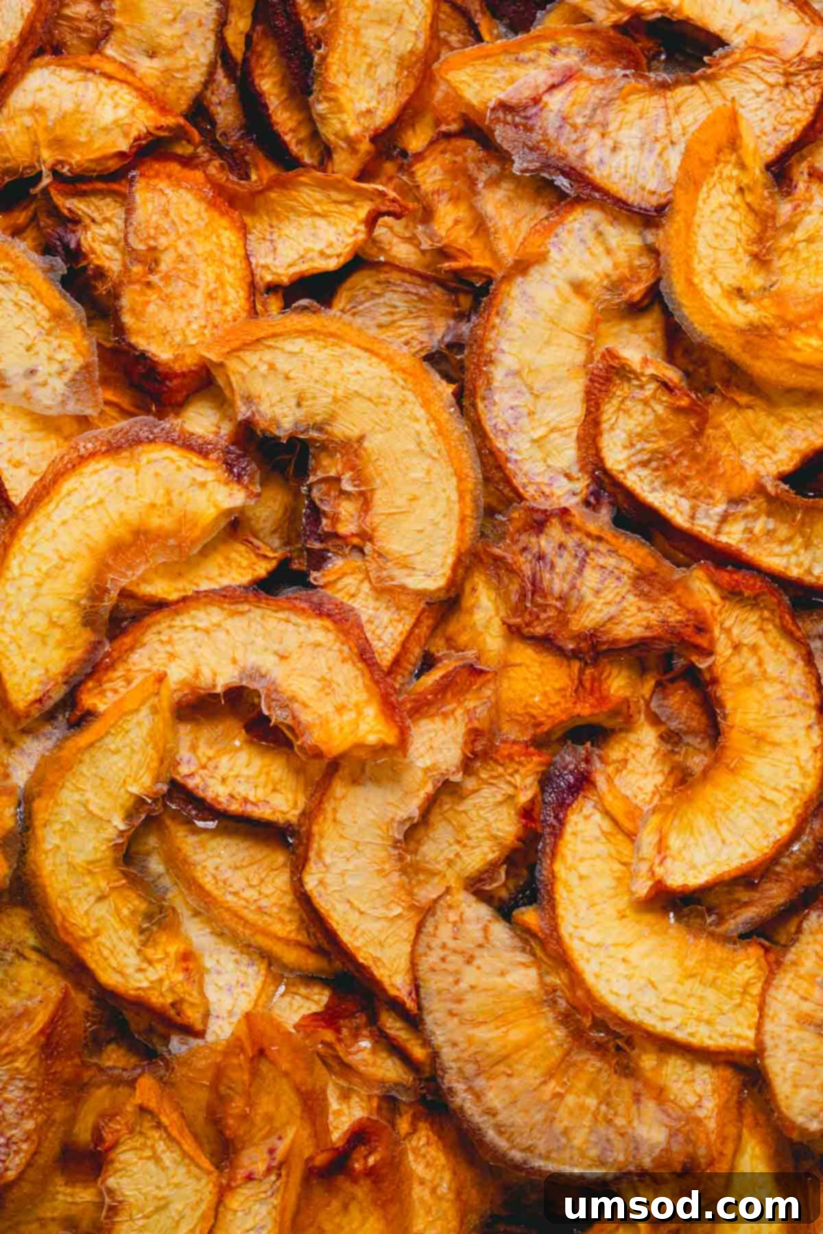 Close-up image of a handful of delicious dehydrated peaches, highlighting their chewy texture.