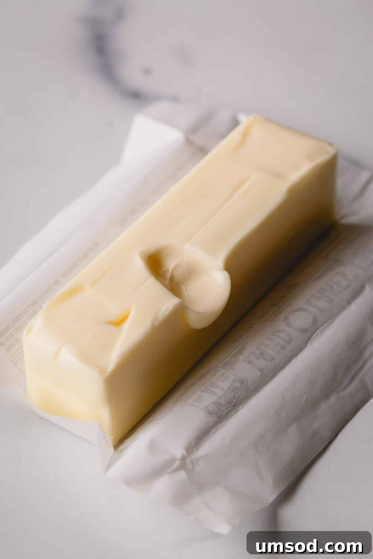 Room Temperature Butter: What You Need To Know 5 A stick of unwrapped butter with a finger dent in the middle.