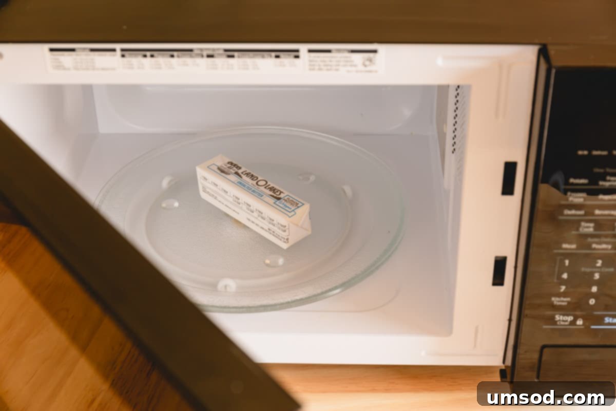 Instant Soft Butter 3 A stick of butter wrapped in its packaging sits inside a microwave, undergoing the quick softening process.