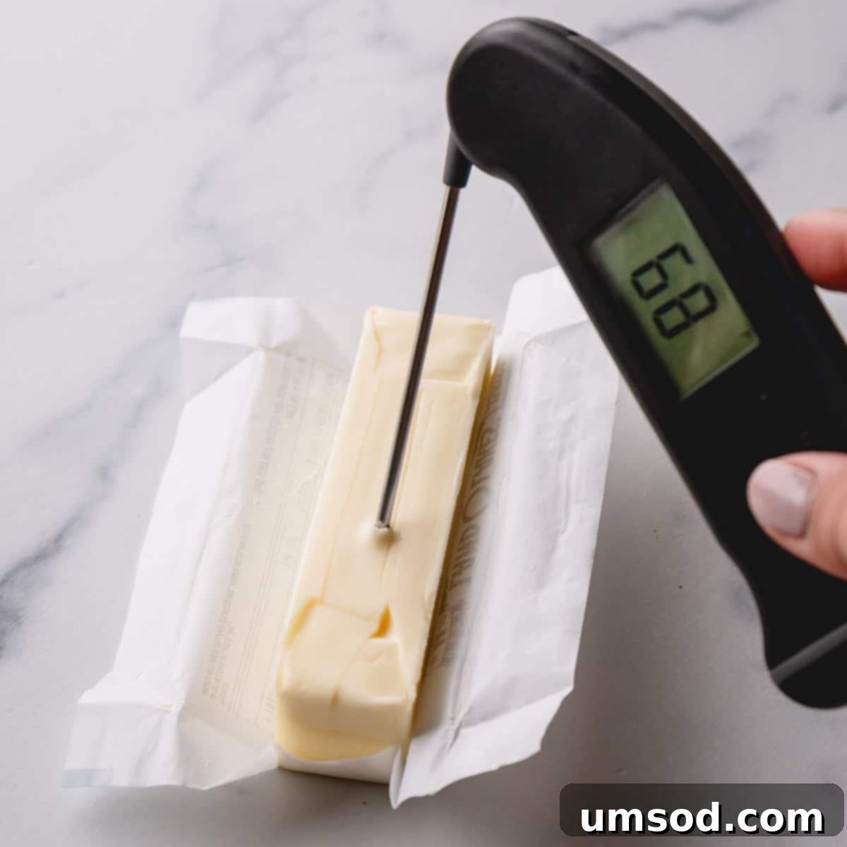 Instant Soft Butter 5 An instant-read thermometer accurately displaying 68°F in a stick of butter, confirming optimal room temperature.