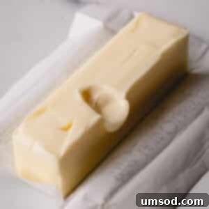 Instant Soft Butter 7 A stick of unwrapped butter with a finger dent, showcasing perfect room temperature for baking.