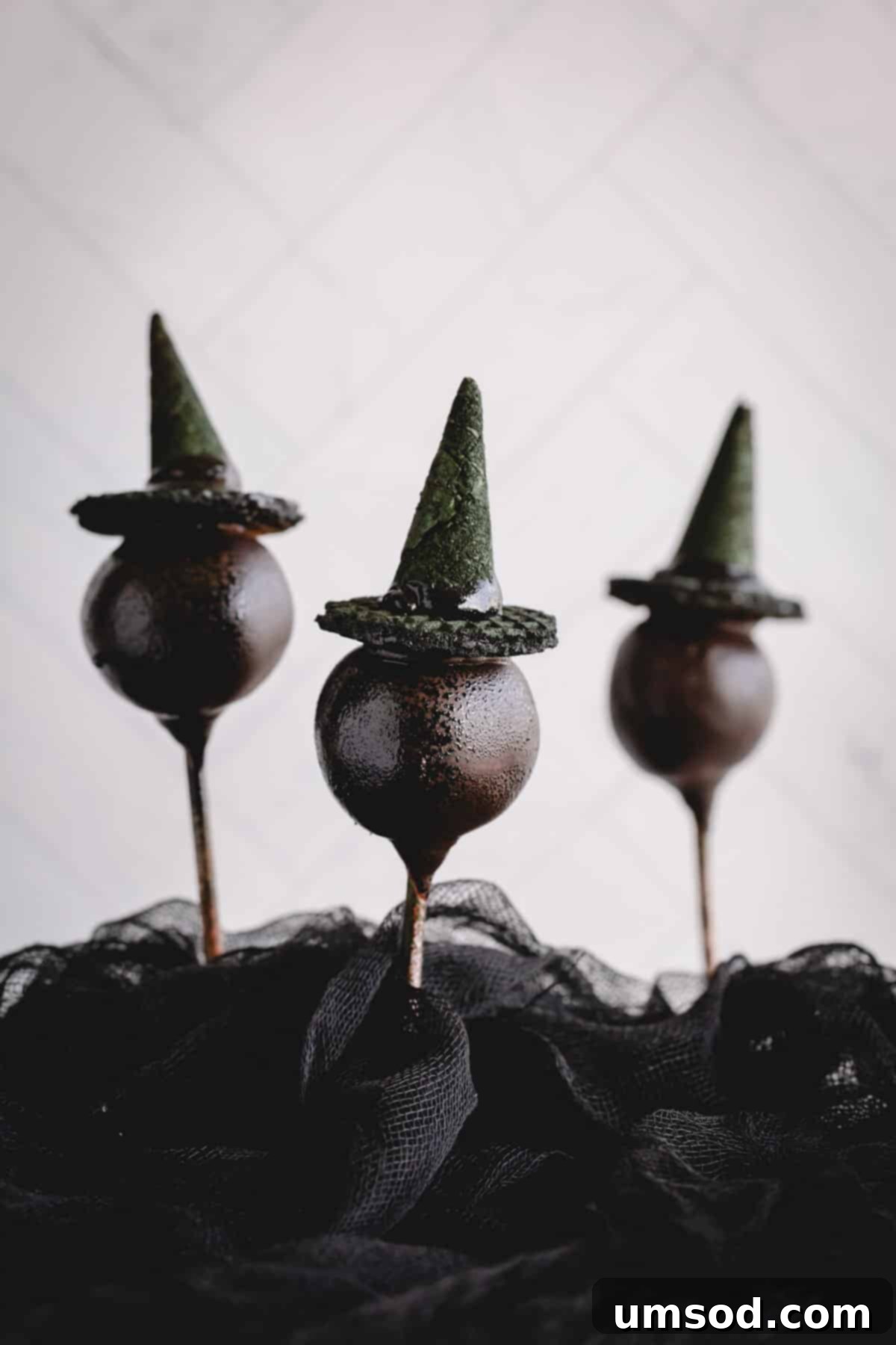 Ghoulishly Good Cake Pops 3 Three chocolate cake pops adorned with whimsical witch hats, standing elegantly.