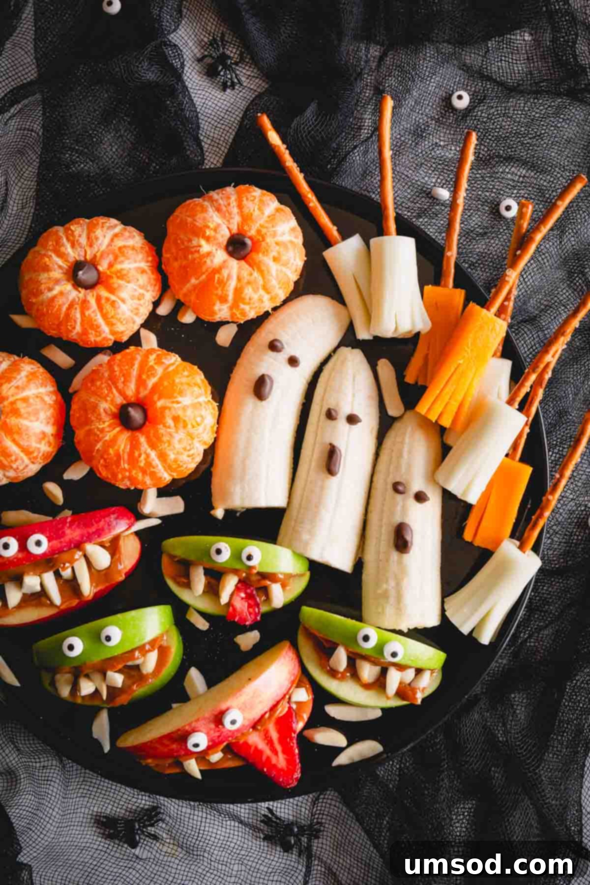 An overhead view of a beautifully arranged healthy Halloween snack board for kids, showcasing all the creative treats.