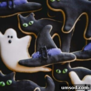Halloween sugar cookies decorated as ghosts, cats, and witch hats.