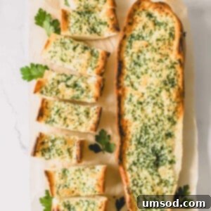 Perfect Garlic Bread in Minutes 8 Two loaves of garlic bread topped with an herbed butter spread with one sliced into pieces.
