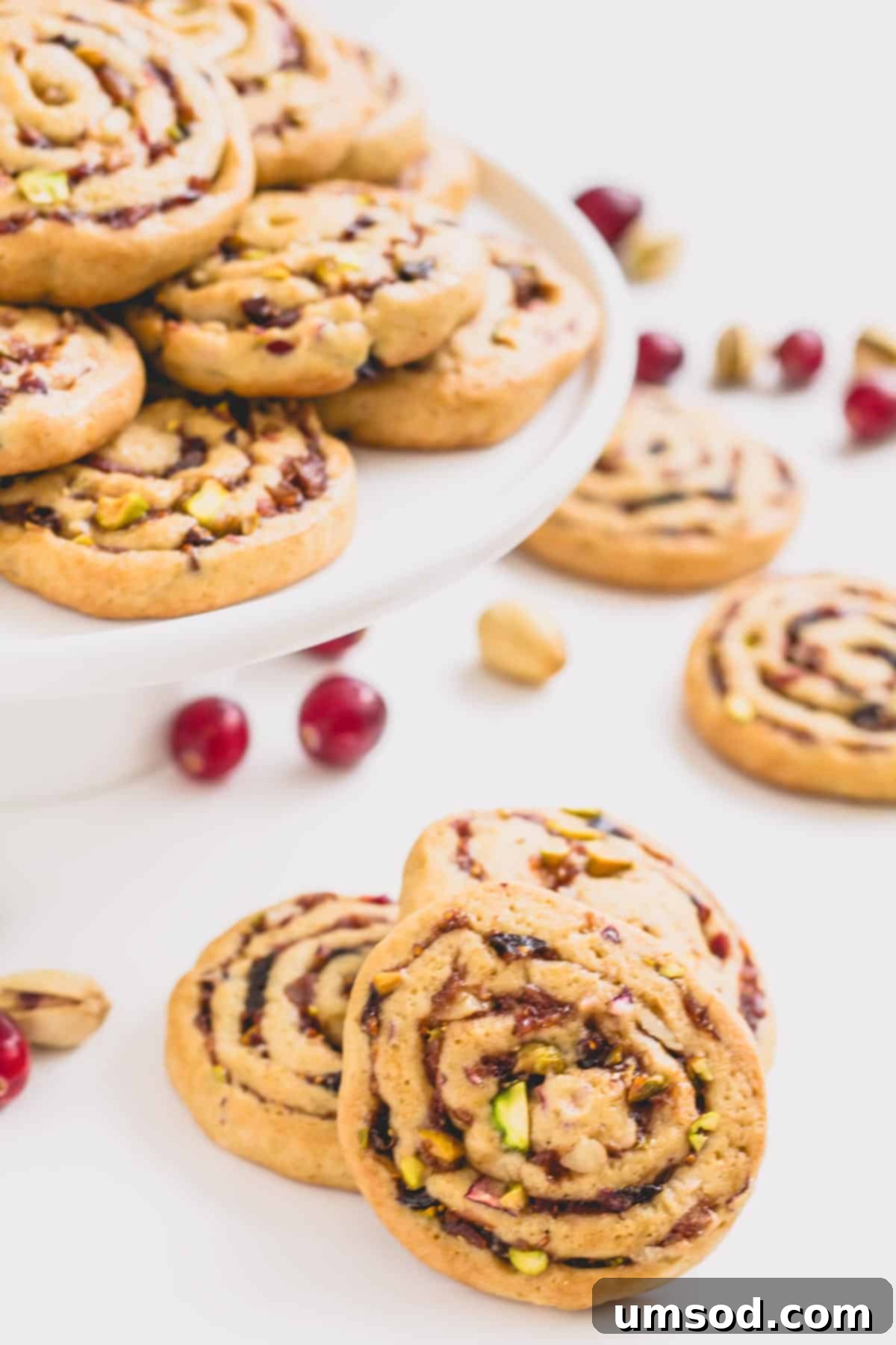 Another enticing shot of fig, cranberry, and date pinwheel cookies on a plate, highlighting their beautiful swirl.