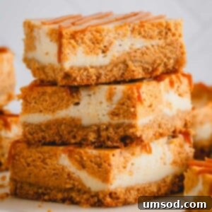 A stack of three pumpkin cheesecake bars with graham cracker crust.