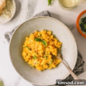 A bowl of saffron risotto with a fork sticking out.