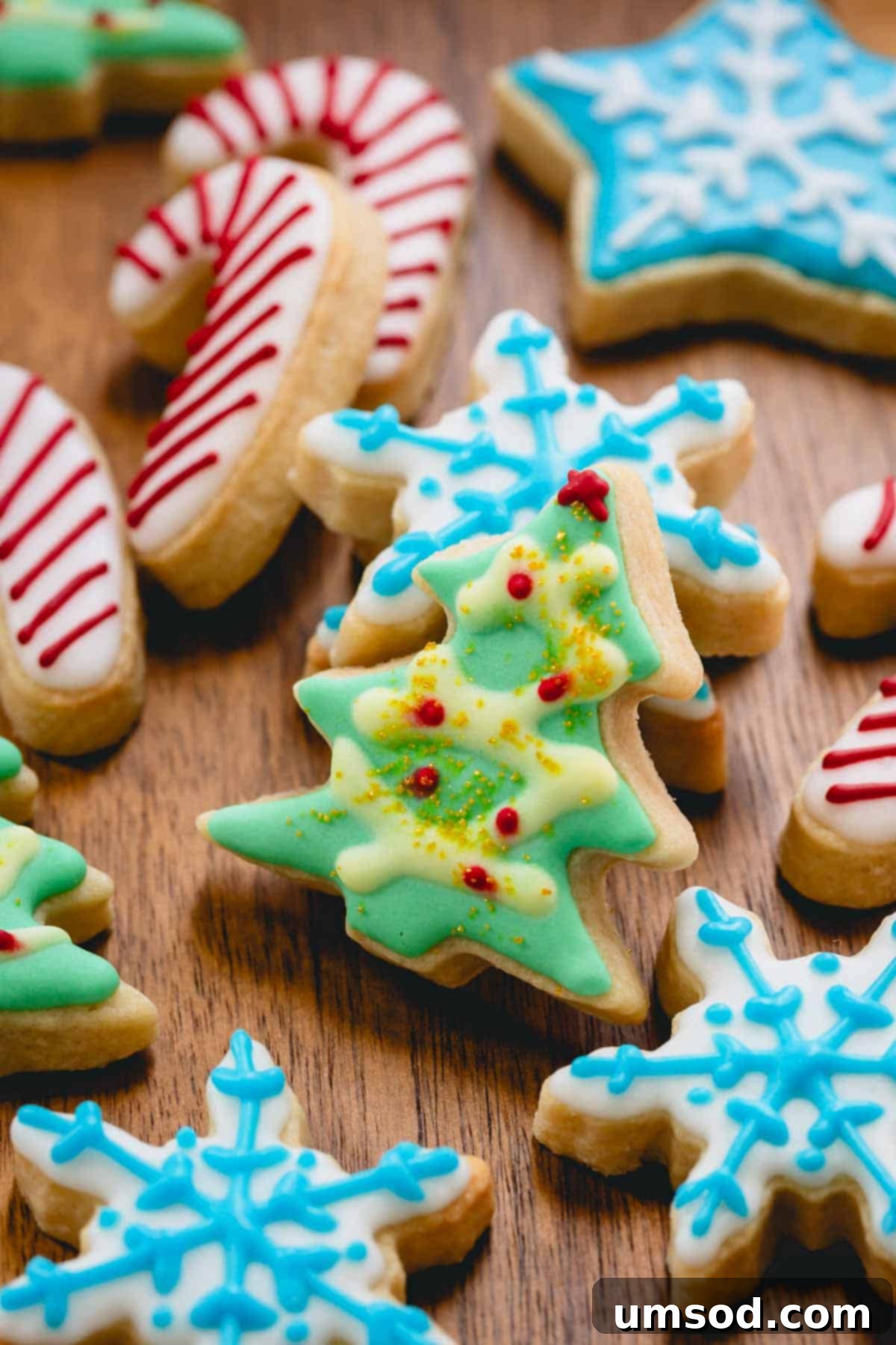 Beautifully iced Christmas sugar cookies in festive shapes like candy canes, Christmas trees, and snowflakes.