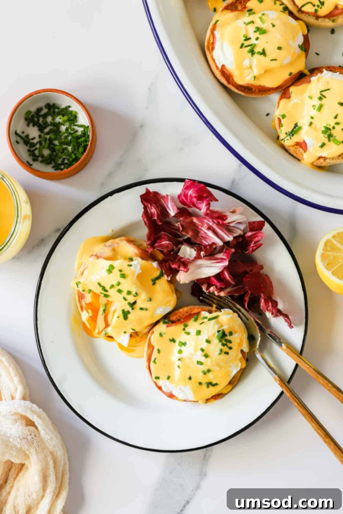 A plated serving of Eggs Benedict, garnished with red cabbage for a vibrant touch.
