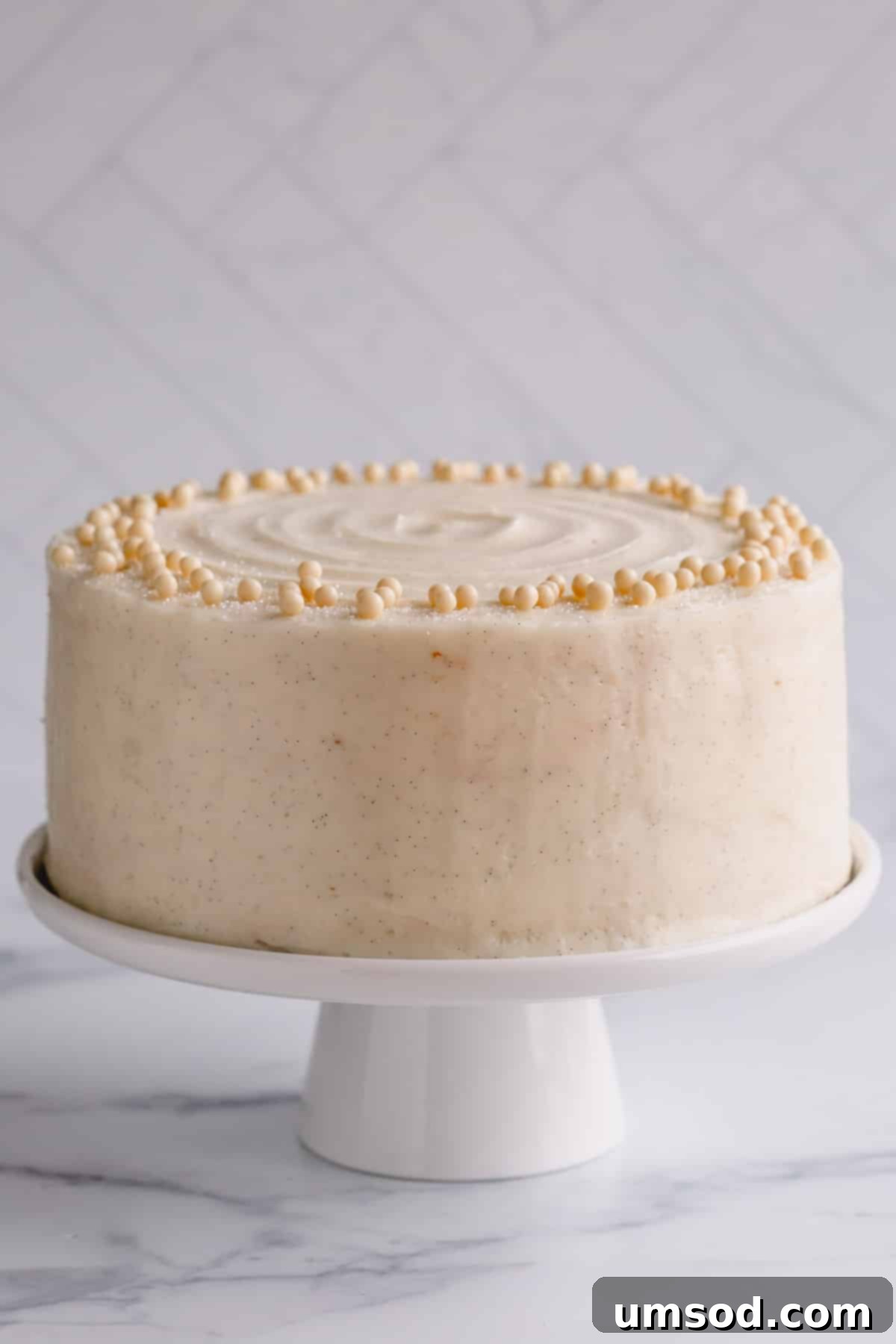 Fluffy White Cake Perfection 2 A classic white cake on a cake stand frosted with pristine vanilla buttercream, ready for a special occasion.