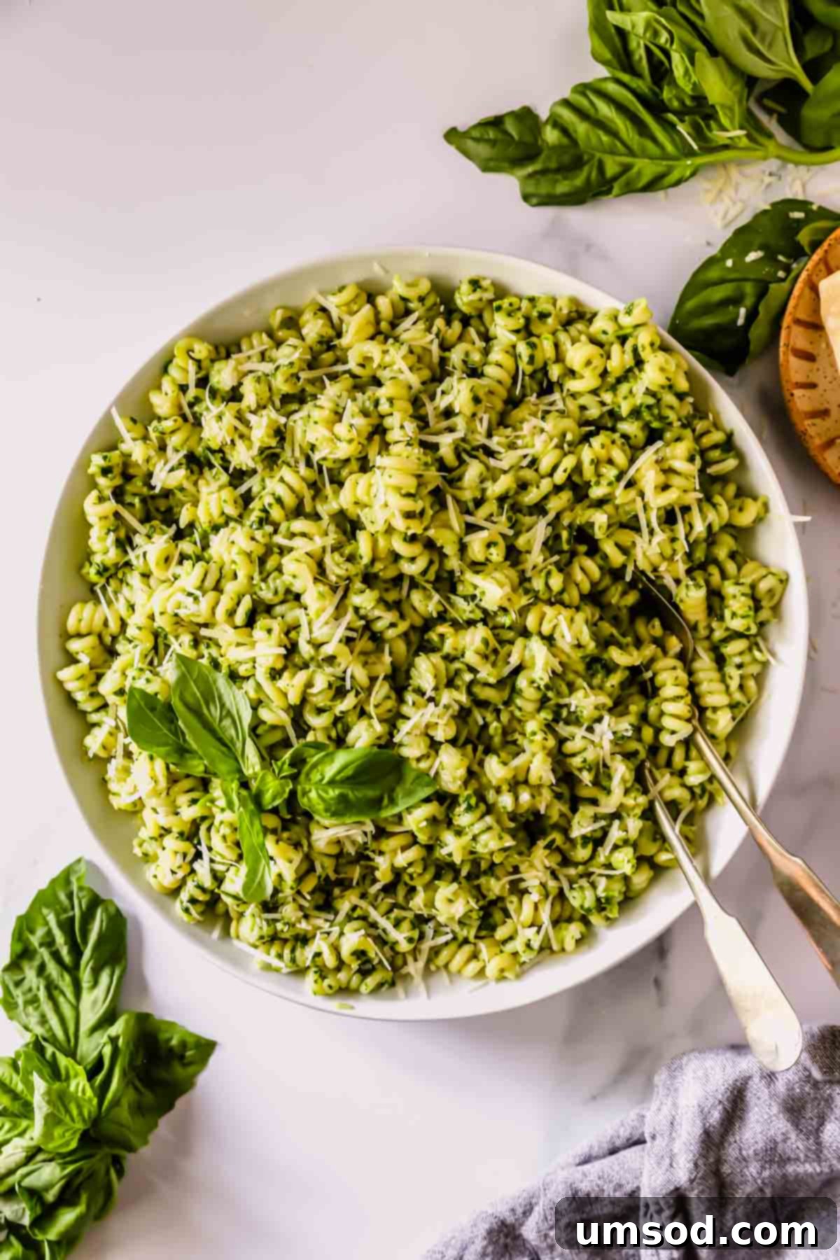 Vibrant Basil Pesto Pasta 7 A bowl of basil pesto pasta with two forks sticking out.