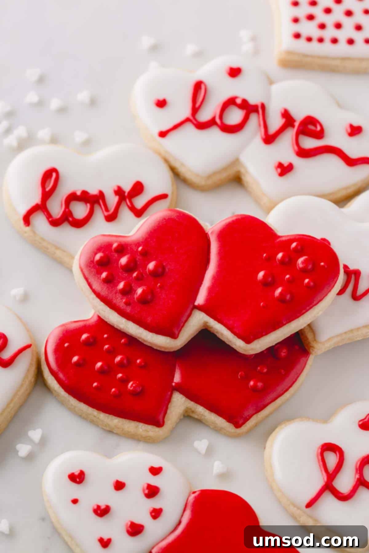 Heart-shaped Valentine's Day sugar cookies with red and white icing, showcasing completed designs.