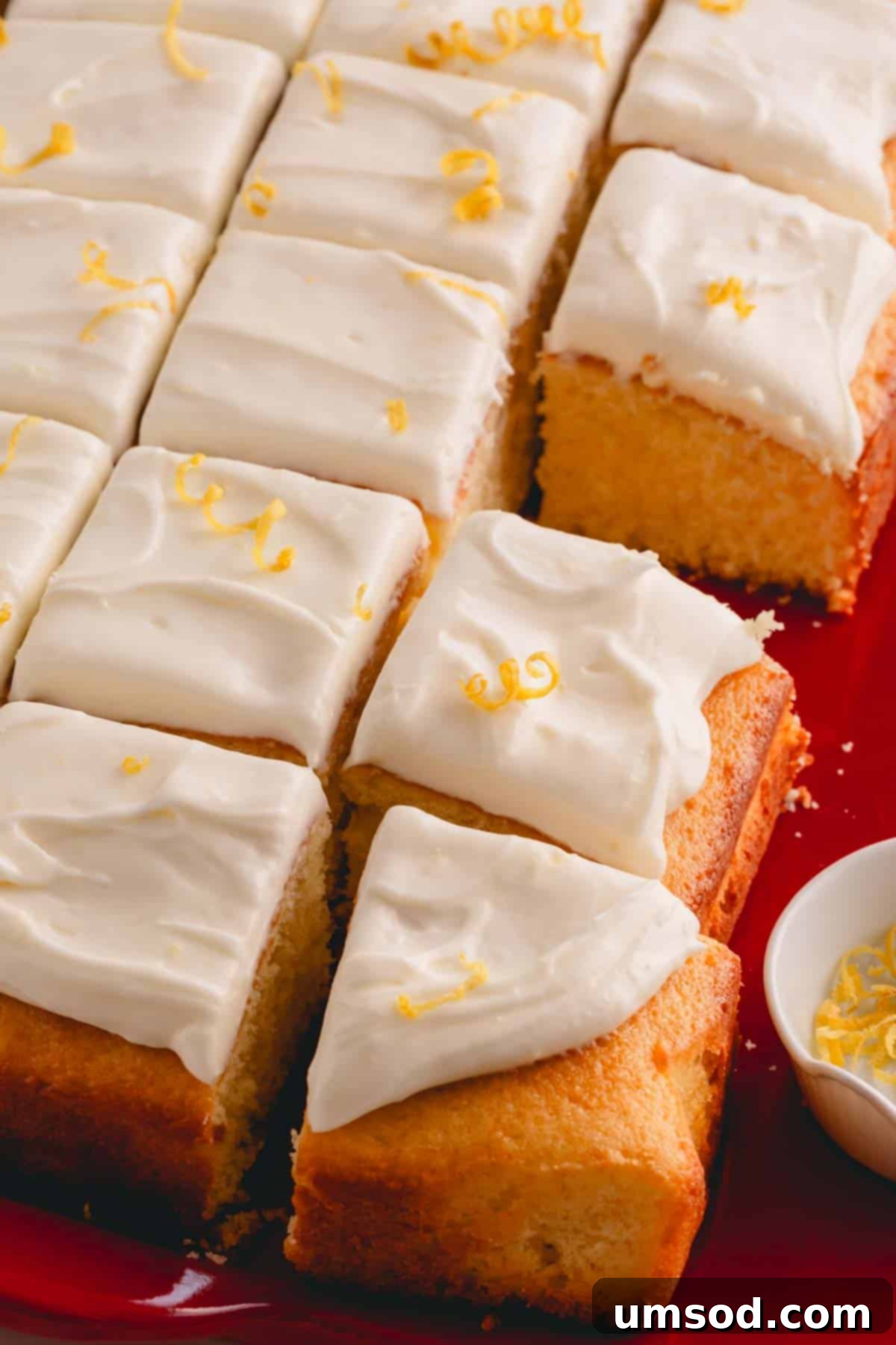 Zesty Lemon Cream Cheese Dream 3 Delicious squares of yellow cake generously topped with homemade lemon cream cheese frosting and lemon zest.