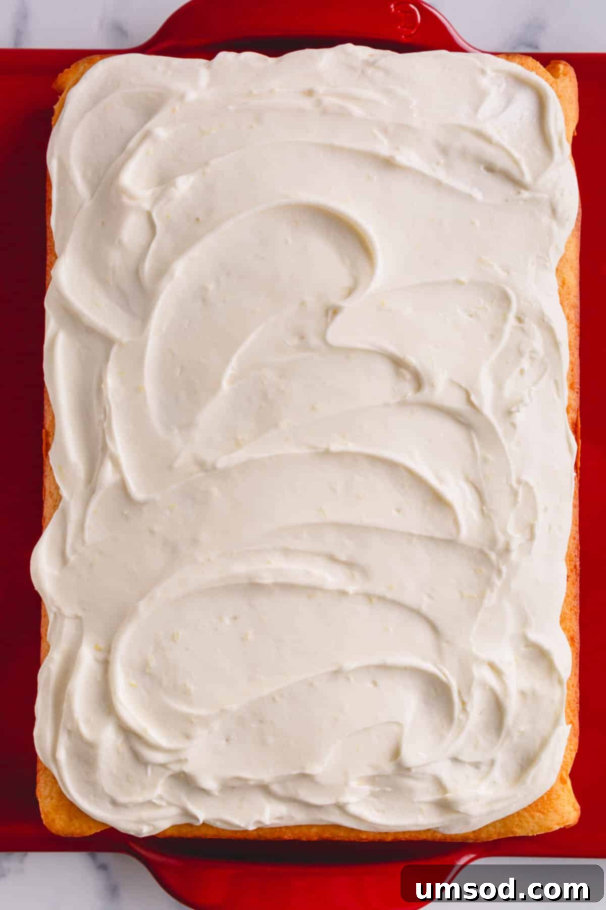 Zesty Lemon Cream Cheese Dream 7 A beautifully frosted yellow cake topped with creamy lemon cream cheese frosting and a delicate lemon slice.