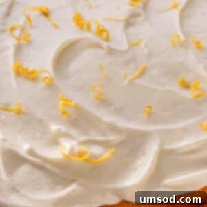 Zesty Lemon Cream Cheese Dream 9 A beautifully decorated cake slice with lemon cream cheese frosting and lemon zest curls, showcasing the recipe.