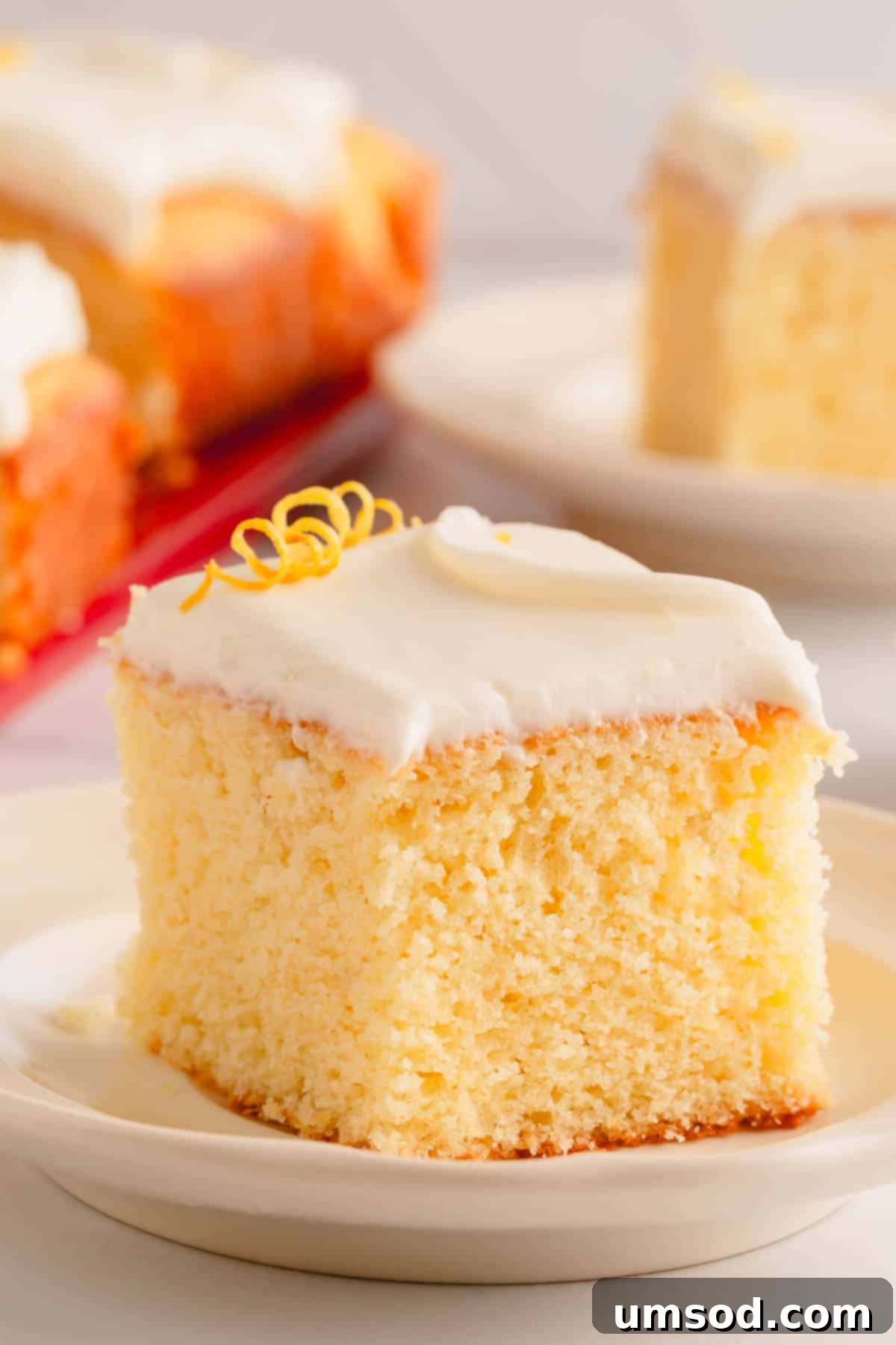 A slice of lemon sheet cake topped with lemon cream cheese icing.