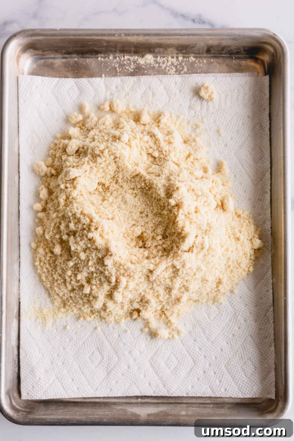 Revive Your Oily Almond Flour 5 Almond flour thinly spread on a baking sheet lined with several layers of paper towel.