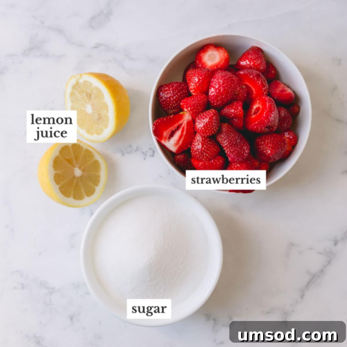 Three essential ingredients for homemade strawberry jam: fresh strawberries, granulated sugar, and bright yellow lemons.