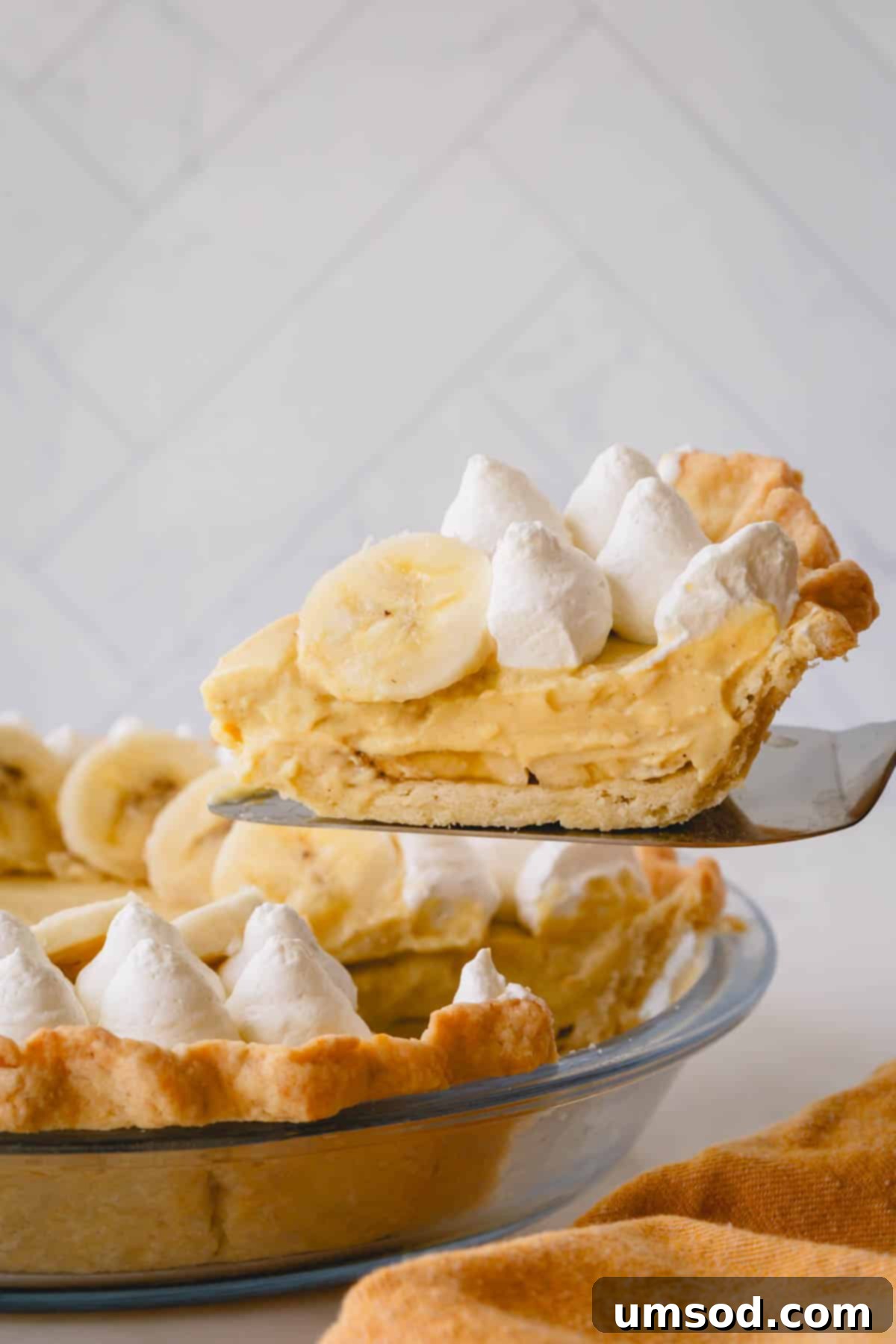 Demystifying Thickening Agents 5 A delectable slice of banana cream pie, showcasing its creamy layers and golden crust, being lifted from the whole pie.