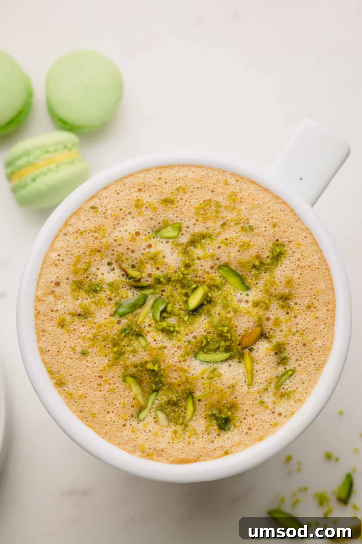 A close-up shot of a creamy pistachio latte, perfectly frothed and topped with finely crushed pistachios, ready to be enjoyed.