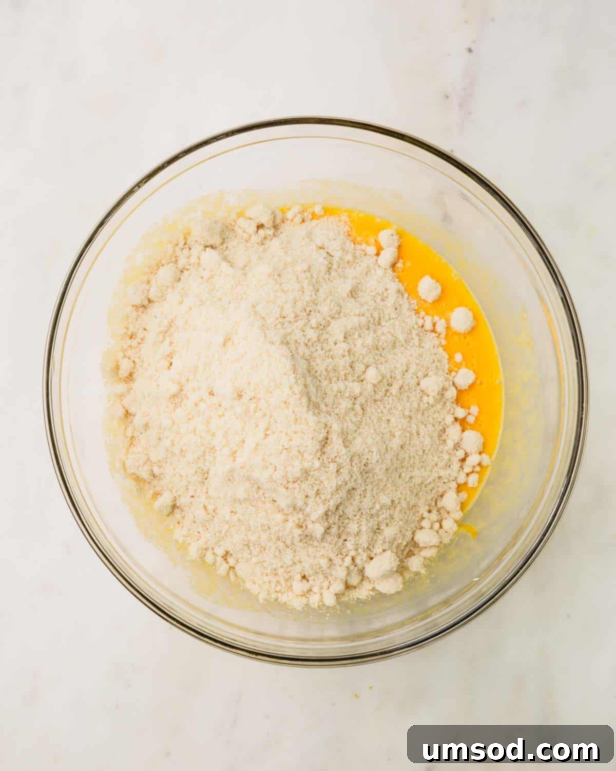 Tender Almond Flour Blueberry Muffins 7 A bowl of wet and dry ingredients for almond flour blueberry muffins.