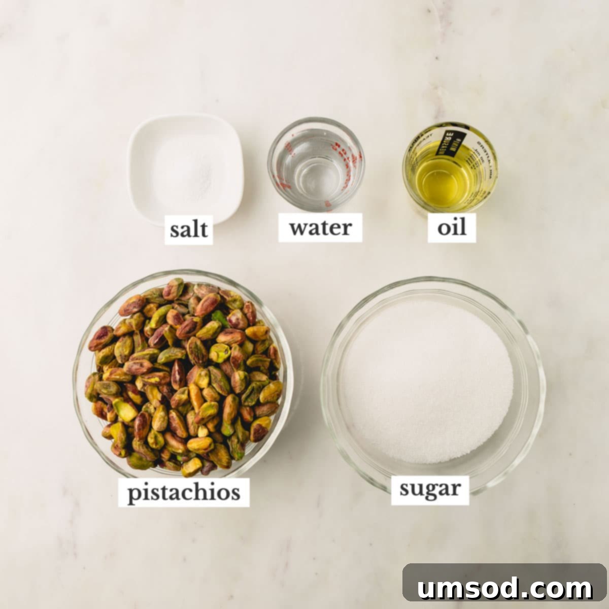 The five key ingredients for making pistachio butter: salt, water, neutral oil, granulated sugar, and raw pistachios.