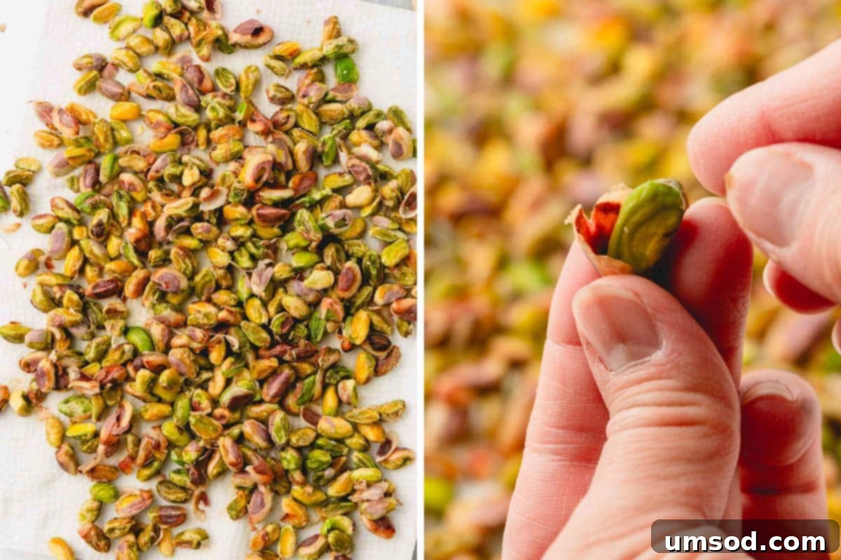 Blanched pistachios on a paper towel, with a hand removing the brown skin, revealing the vibrant green nut.