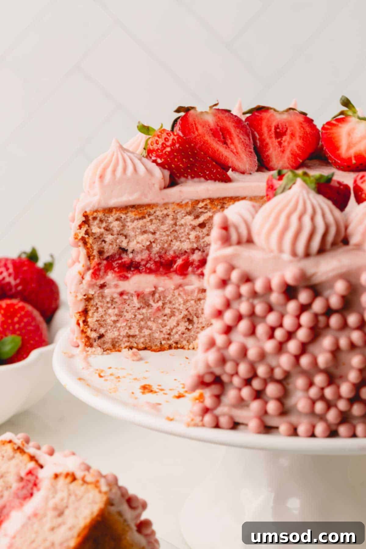 Berry Sweet Symphony 20 A two layer strawberry cake with a slice missing, exposing the strawberry sauce in the center.