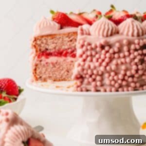 Berry Sweet Symphony 21 A two layer frosted strawberry cake on a cake stand with a slice missing.