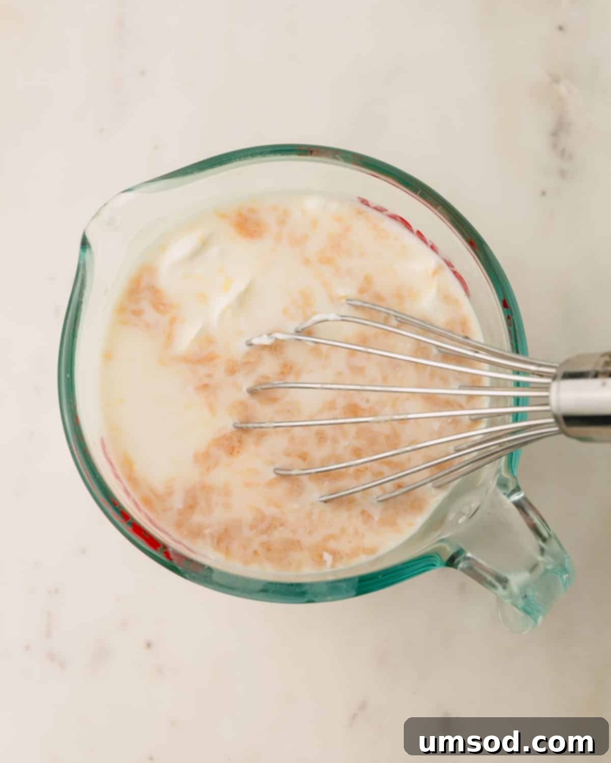 Berry Sweet Symphony 7 Wet ingredients for strawberry cake batter being whisked in a liquid measuring cup.
