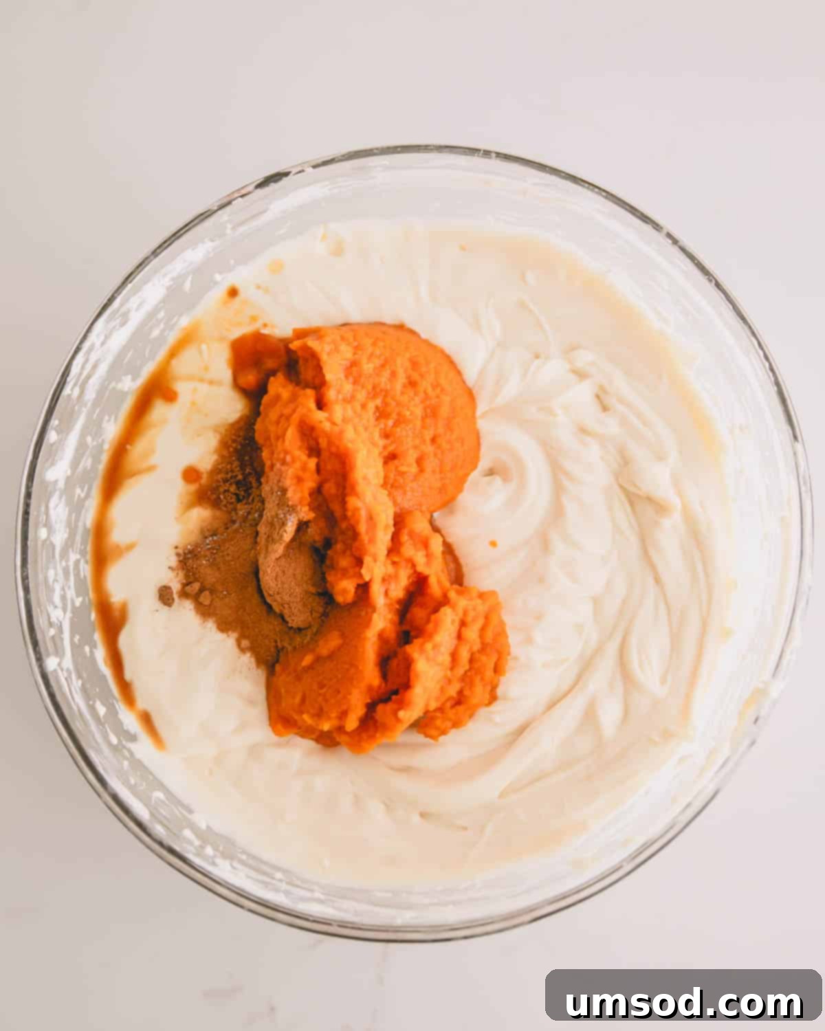 A bowl of whipped cream with pumpkin, spices, and vanilla.