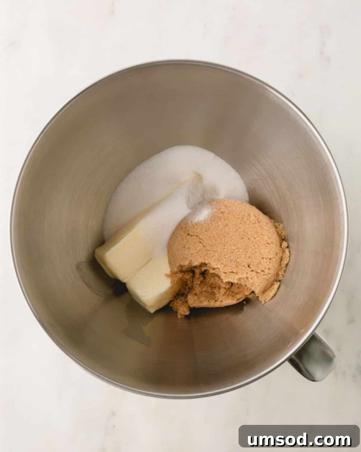 White sugar, brown sugar, and butter in a bowl before mixing.