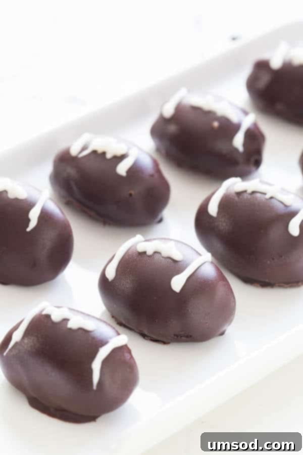 Gourmet Triple Chocolate Oreo Truffles 4 Close-up of football-shaped OREO cookie balls with white chocolate laces