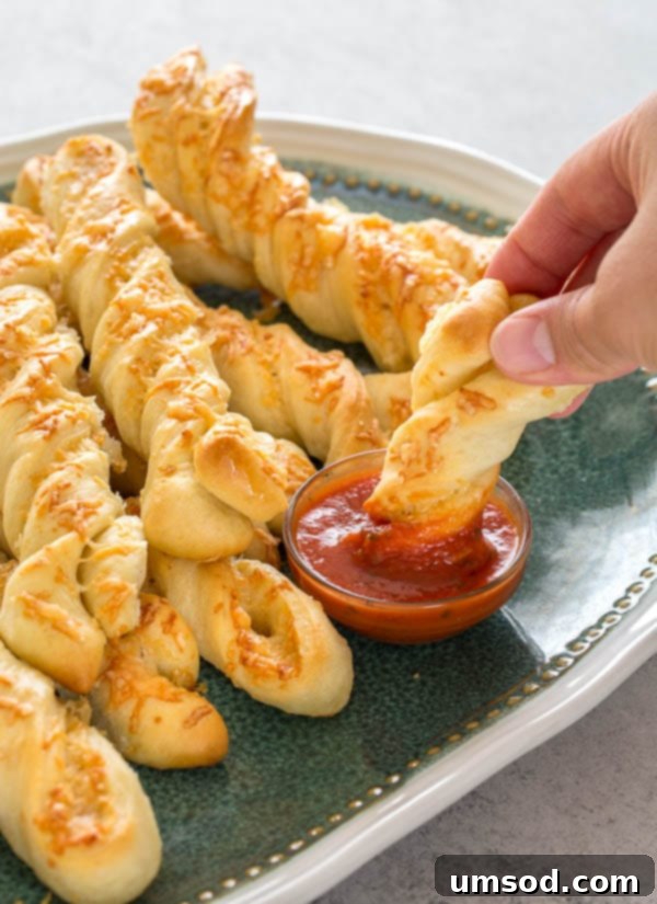 Crispy Garlic Breadsticks 6 A basket full of freshly baked, golden-brown roasted garlic and cheese breadsticks, steam subtly rising.