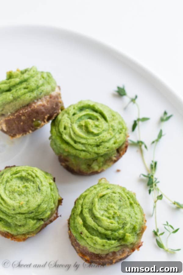 Individual shepherd's pies topped with decorative green mashed potato swirls, ready to be served as a party appetizer.