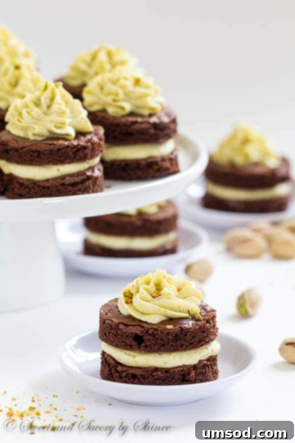 A selection of mini chocolate layer cakes with pistachio buttercream, showcasing their adorable size and perfect frosting swirls, ready to be served.