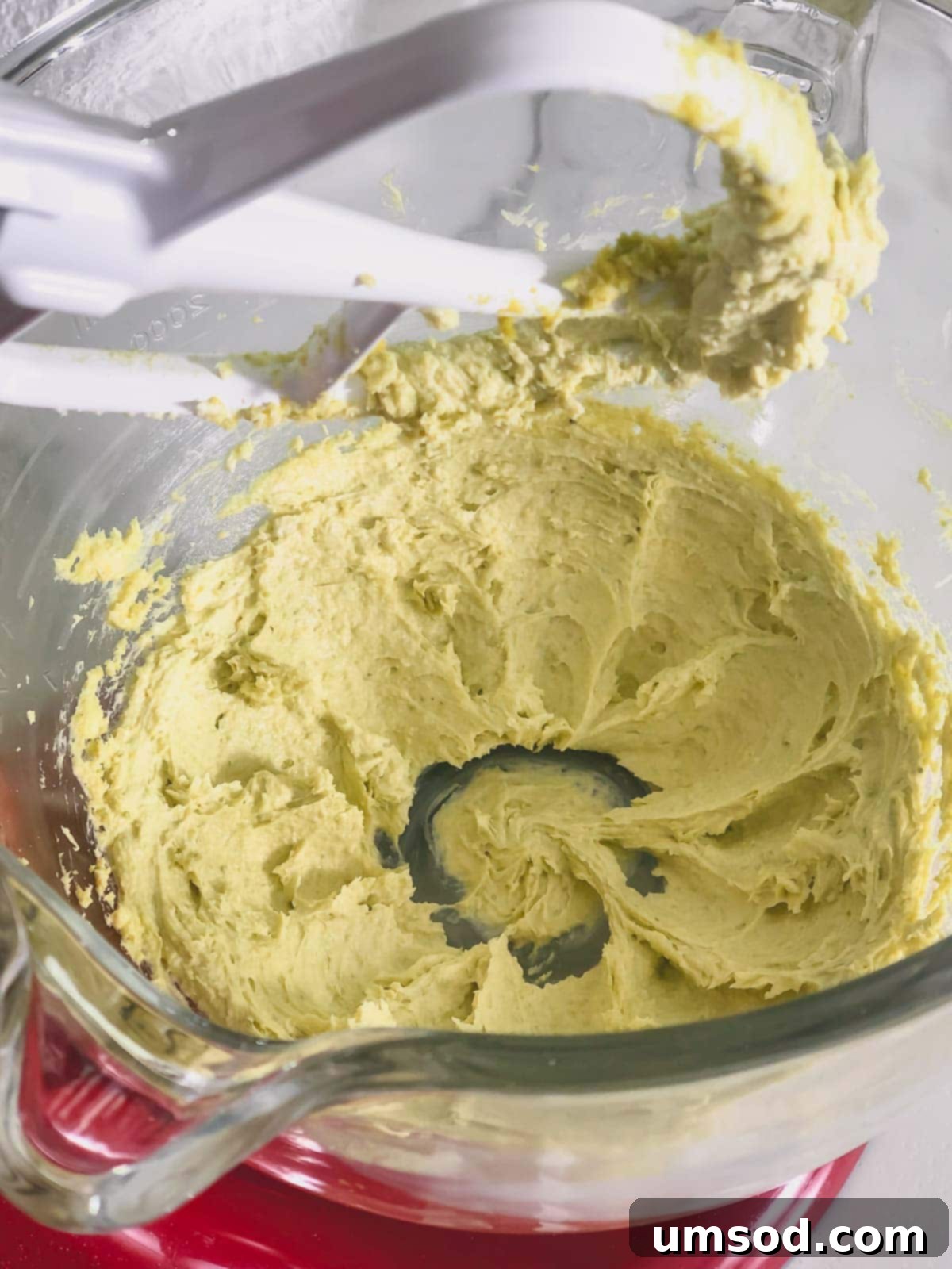 Pistachio buttercream in a mixing bowl, showing its creamy texture before piping.