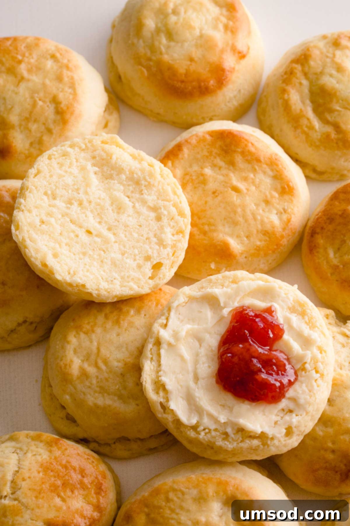Sliced scone with butter and jam, ready for serving.