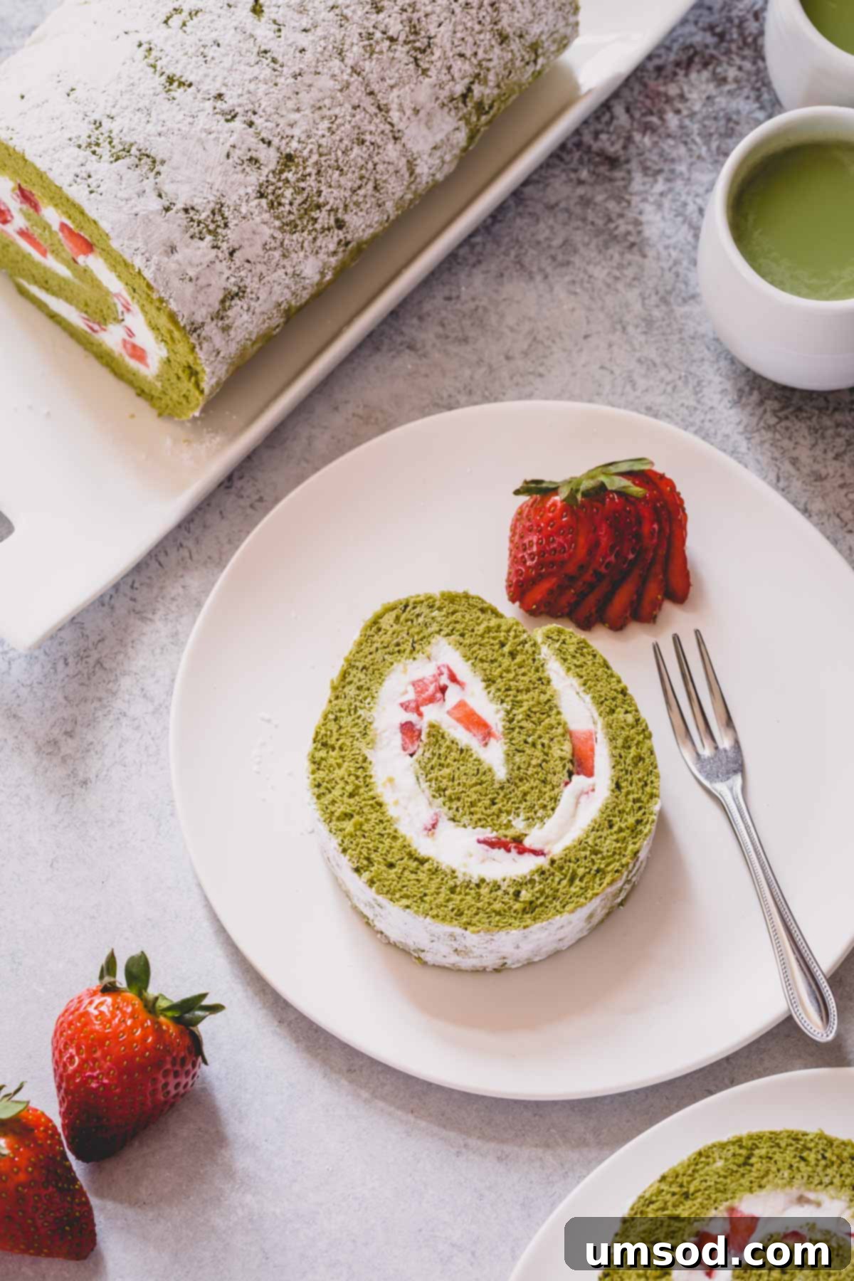 Matcha Strawberry Swirl Cake 8 A slice of strawberry matcha roll cake on a white serving plate.