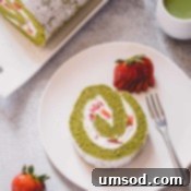 Matcha Strawberry Swirl Cake 10 A slice of strawberry matcha roll cake on a white serving plate.