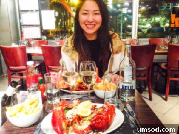 Person Enjoying Grilled Lobster with Fries
