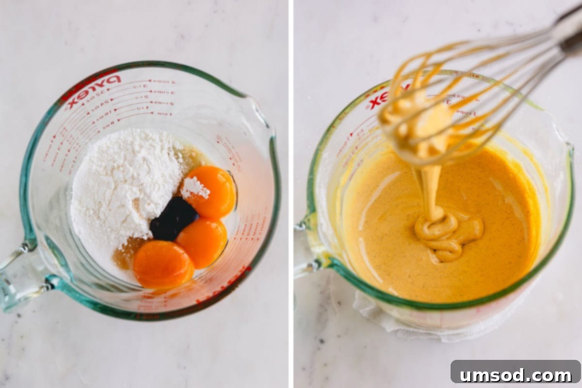 A liquid measuring cup with egg yolks, sugar, cornstarch, vanilla extract, vanilla bean paste and salt.